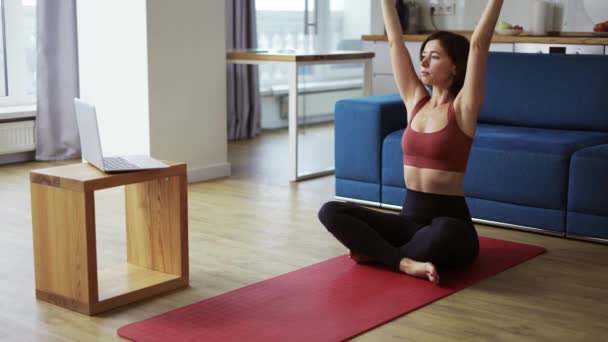 Woman practicing yoga with trainer via video conference - warming up hands — Stock Video