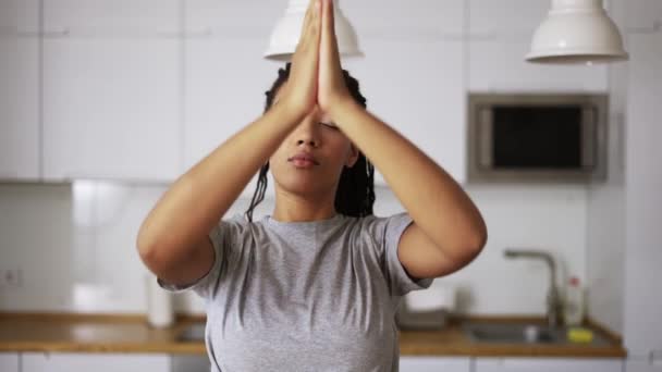 Ung afrikansk kvinna gör meditation hemma, ansluter händerna i namaste — Stockvideo