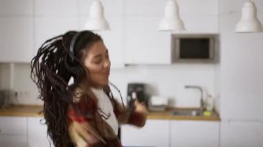 Mutlu havalı siyah kız evde tek başına dans ediyor, ağır çekimde.