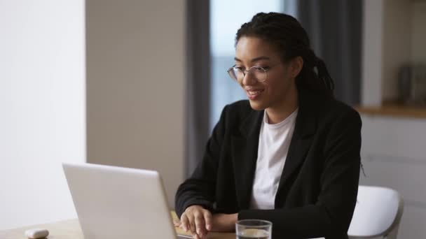 Афро-американская девушка секретарь бизнес-женщина сидит за столом в офисе с помощью ноутбука, замедленной съемки — стоковое видео