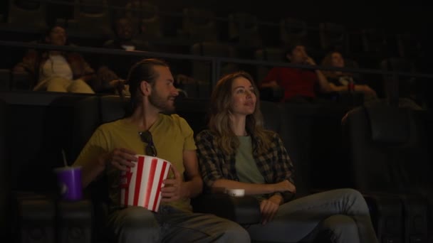 Pareja tener una cita en el cine, sentado abrazando — Vídeos de Stock