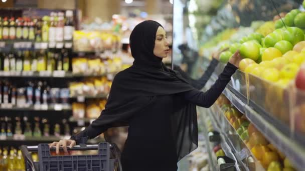 Мусульманка, покупающая продукты в супермаркете — стоковое видео