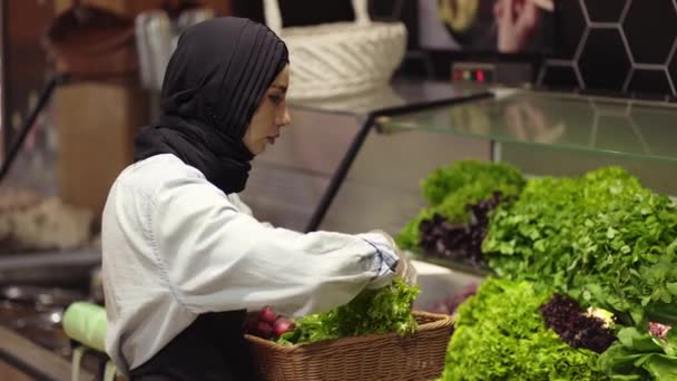 Dame im Hijab füllt frisches Grünzeug im Supermarktregal nach — Stockvideo