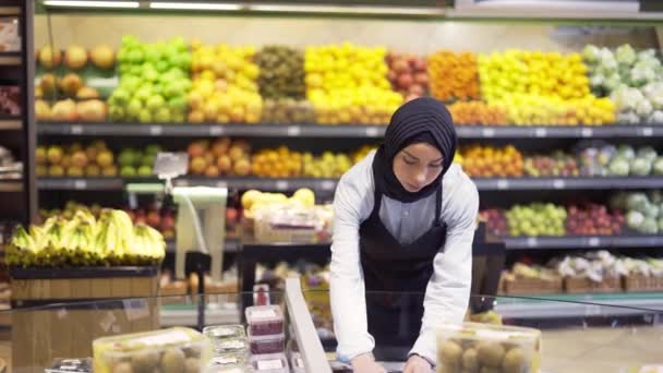 Wanita muslim mengatur ulang produk di supermarket — Stok Video