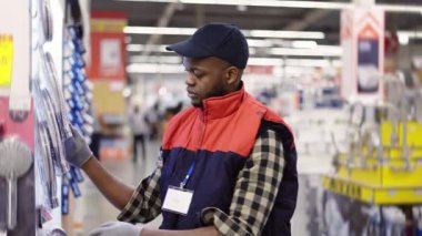 Satış elemanı ev hipermarketinde ürünleri düzenliyor.