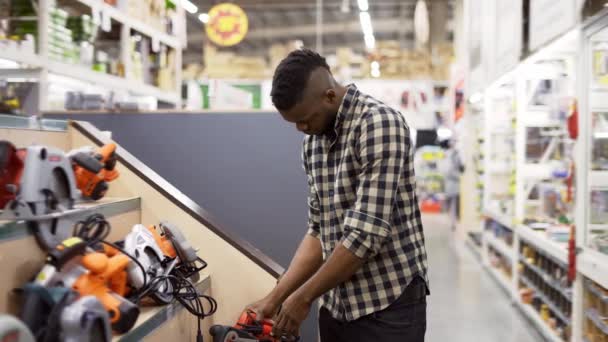 Afrykański amerykański nabywca wybiera narzędzie do budowy i naprawy warsztatów w pomieszczeniach — Wideo stockowe
