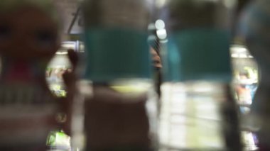 Türbanlı kadın ve koruyucu maskeli kadın raftan su şişesi, içeriden görüntüler.