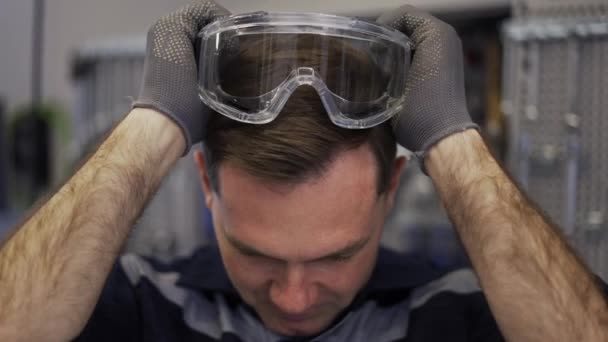Bir araba tamircisi koruyucu gözlük takıyor. — Stok video