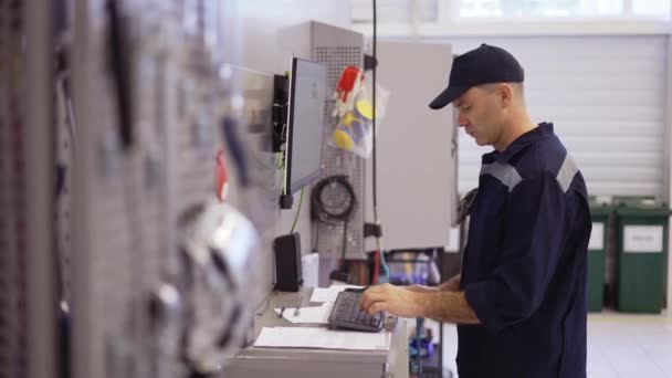 Mecánico en el ordenador de uso uniforme para su trabajo para la fijación de coches rotos — Vídeos de Stock