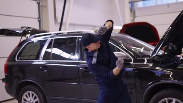 Gelukkige monteur man dansen grappig in een moderne dienst auto centrum, slow motion — Stockvideo