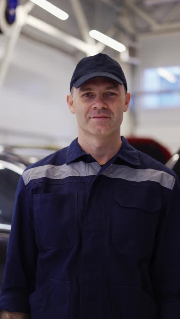 Retrato de um mecânico sorridente reparando em uniforme de pé olhando câmera, de perto — Vídeo de Stock
