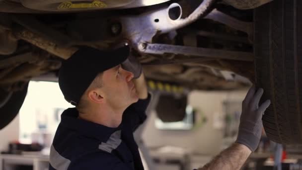 Car service worker examinating car fails with lighter in hands — Stock Video