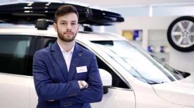 Araba galerisindeki genç araba satıcısının portresi, çapraz kollarla duruyordu.