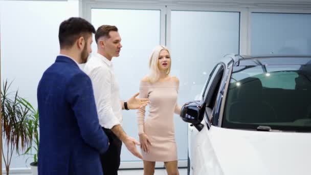 Dość młoda elegancka para wybiera samochód w salonie — Wideo stockowe