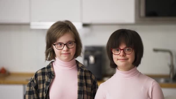Portret van twee gelukkige meisjes met dons syndroom in bril — Stockvideo