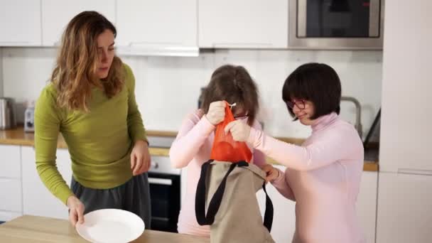 Σύνδρομο Down κορίτσια με τη μητέρα στην κουζίνα με ψώνια — Αρχείο Βίντεο
