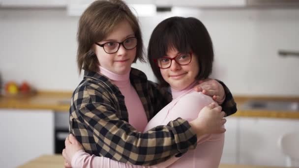 二つの幸せな女の子でダウン症候群で眼鏡立って一緒に抱擁 — ストック動画