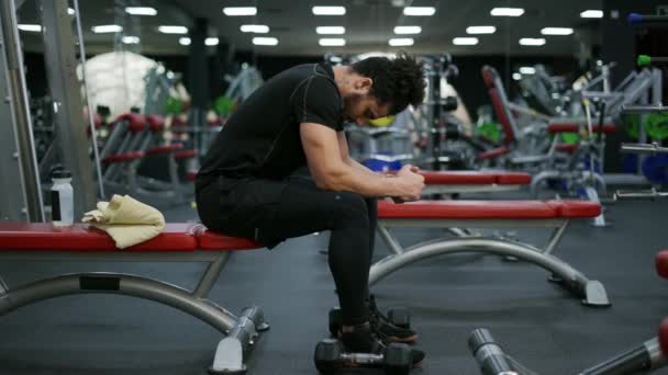 Hombre Sentado Respirando Después Terminar Curso Entrenamiento Con Pesas Gimnasio — Vídeo de stock