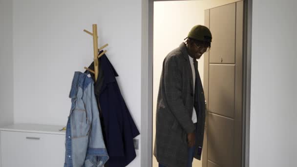 Seorang Pria Dengan Pakaian Trendi Membuka Pintu Memasuki Rumah Dan — Stok Video