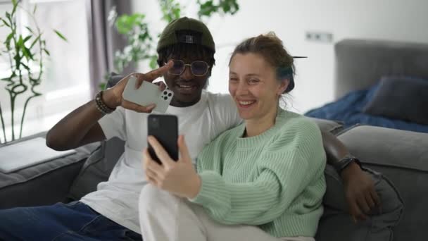 Çift Irklı Mutlu Çift Koltukta Oturuyor Akıllı Telefondan Video Görüşmesi — Stok video
