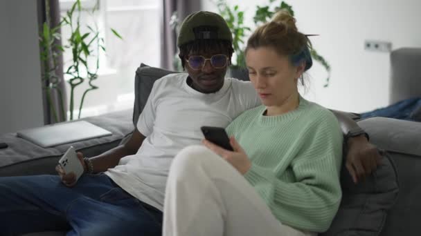 Feliz Casal Biracial Relaxante Sofá Com Smartphone — Vídeo de Stock