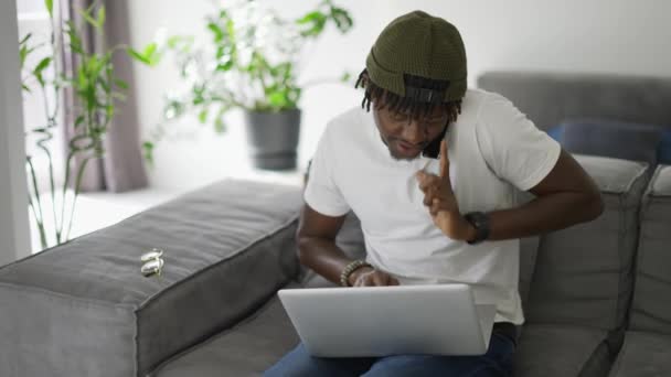 Homem Africano Usando Smartphone Usar Laptop Sofá — Vídeo de Stock
