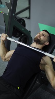 Erkekler spor salonunda ağırlık kaldırma egzersizi yapıyor..