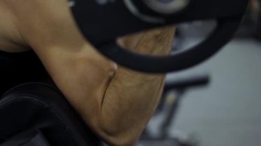 Spor salonunda ağırlık kaldıran adamların bisepslerini kapatın..