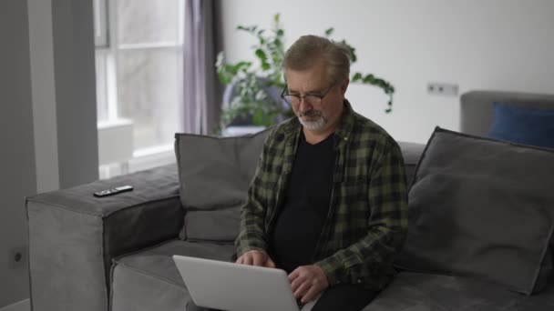 Senior Older Mature Man Typing Laptop Browsing Internet Sit Sofa — Vídeos de Stock