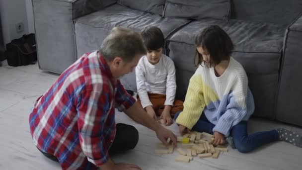 Szczęśliwe Dzieci Bawiące Się Drewnianego Konstruktora Podłodze Dziadkiem — Wideo stockowe