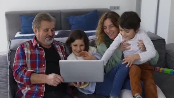 幸せな家族世代 2人の孫と娘がノートパソコンでソファに座っている — ストック動画