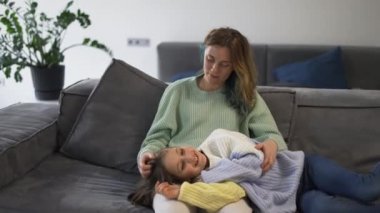 Anne ve küçük kızı kanepede birbirlerine bağlanıyorlar..
