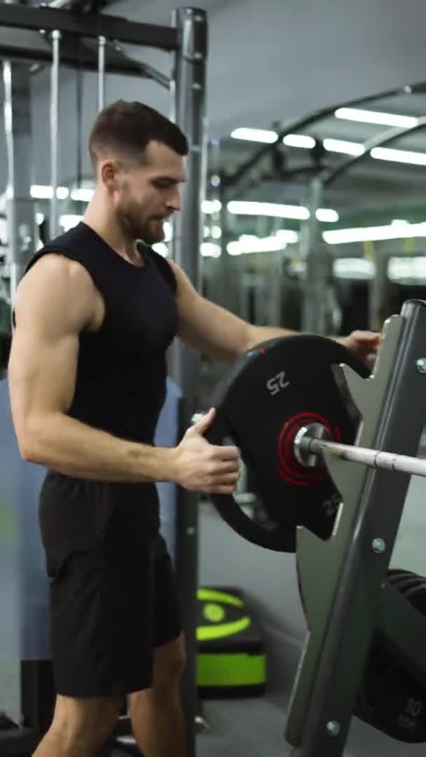 Atleta Masculino Preparando Para Treino Intensivo Carregando Placas Pesadas Barra — Vídeo de Stock