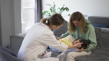 Doktor, bebeğin dizlerindeki ısıyı kontrol ediyor..