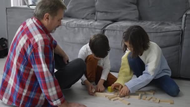 Ευτυχισμένα Παιδιά Παίζουν Ξύλινο Κατασκευαστή Στο Πάτωμα Τον Παππού Αργή — Αρχείο Βίντεο