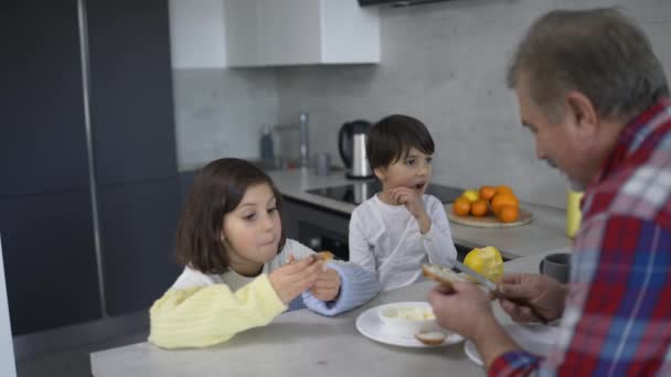 Two Small Children Eating Sandwiches Made Grandfather — ストック動画