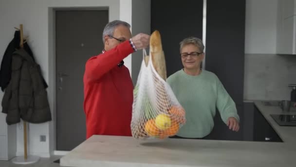 Portrait Happy Retired Married Couple Coming Home Shopping Unpacking Bags — Stock video