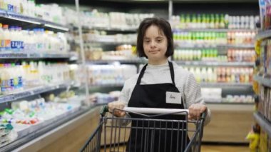 Store employee with Down syndrome pushing shopping cart in a local supermarket, slow motion.