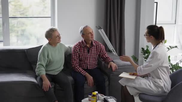 Doctor Talking Senior Couple Home Nursing Home — Stockvideo