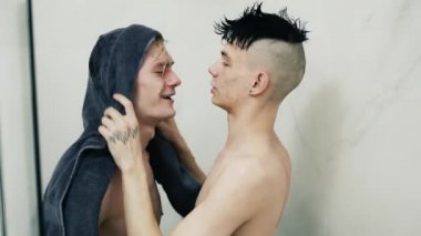 Cute couple of men with towel drying his boyfriend after shower.