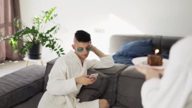 Male gay couple: a man surprising boyfriend with cake and candle.
