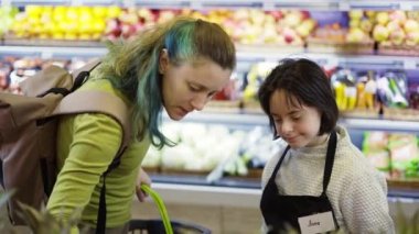A shop worker with Down syndrome helping customer to choose fresh fruits.