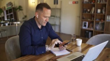Businessman in headphones communicates on the phone by video link. Discussion of important matters online.