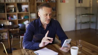 Businessman in headphones communicates on the phone by video link. Discussion of important matters online.