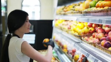 Asian girl worker puts goods on the shelf. Filling shelves with goods.