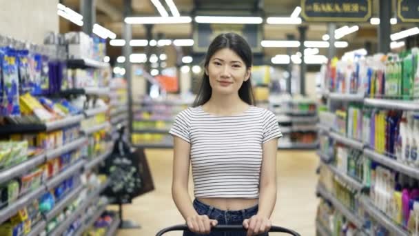 Happy Asian Girl Walks Supermarket Shopping Cart Looking Camera Shopping — Stok Video