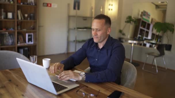 Adult Man Sitting Laptop Adult Man Takes Sip Coffee Leans — Stock Video