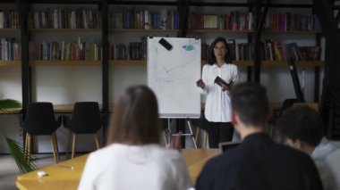 Üniversite öğrencileri grup çalışması. Proje hazırlamak, not almak, mutlu gençlik takımı kompozisyon özeti yazmak takım çalışması öğrenmek kütüphanede yaratıcı araştırma ödevi yapmak.