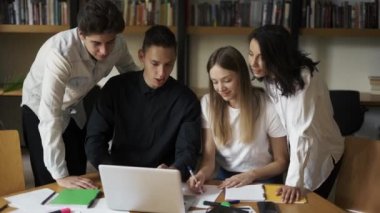 Üniversite öğrencileri grup çalışması. Proje hazırlamak, not almak, mutlu gençlik takımı kompozisyon özeti yazmak takım çalışması öğrenmek kütüphanede yaratıcı araştırma ödevi yapmak.