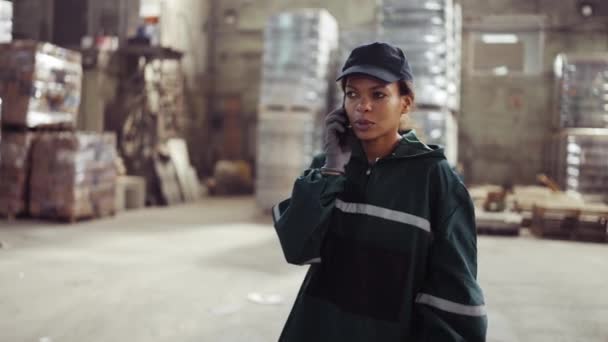 Femeie Afro Americană Într Uniformă Verde Specială Vorbește Telefon Fabrică — Videoclip de stoc